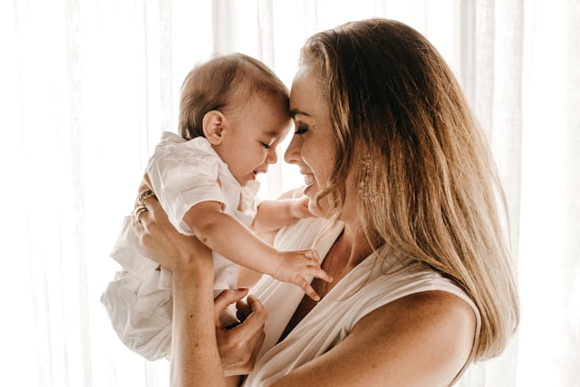 Junge Mutter mit Baby im Arm. Die Mutter ist bereit für die Rückbildung nach der Schwangerschaft